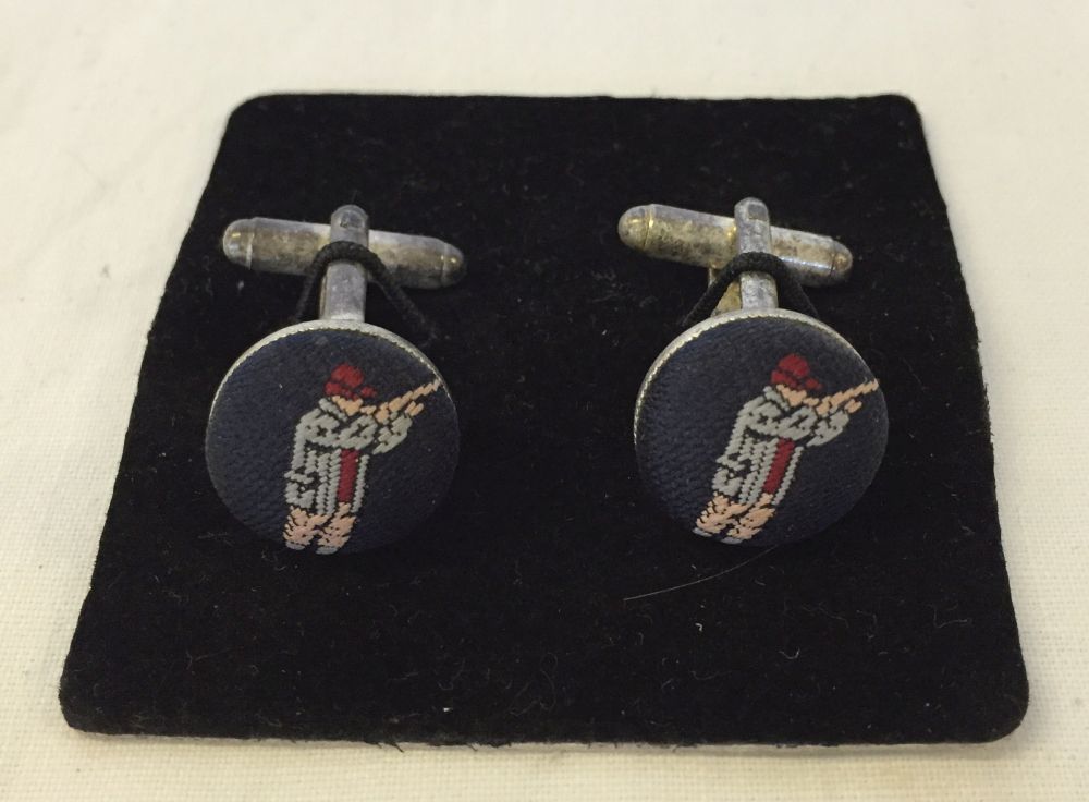 A pair of gents cufflinks with fabric 'Hunter with shotgun' decoration.