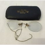 A cased pair of vintage spectacles with ear loop. Metal marked 12K G F.