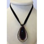 A large Wedgwood purple cut glass pendant on velvet ribbon.