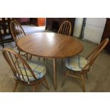 An oval drop leaf table & 4 stickback chairs, probably Ercol.