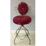 A boudoir chair with orange spotted pink upholstery.