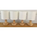 4 wooden bedside lamps with white shades.