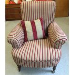 A Victorian armchair recently upholstered in red and gold striped fabric.