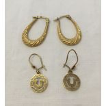 2 pairs of 9ct gold earrings, one elongated hooped pair and a pair of lucky horse shoe drop