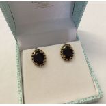 A large pair of 9ct gold earrings set with oval garnets. Approx weight 2.8g.