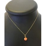 Carved coral pendant set in a hallmarked 9ct gold mount on a 9ct chain.