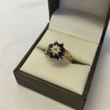 9ct gold ladies dress ring, set with a central diamond surrounded by 8 sapphires. Size O, total