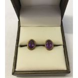 A pair of 9ct gold oval stud earrings set with amethysts.