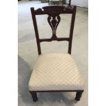 An Edwardian carved back nursing chair in oatmeal upholstery.