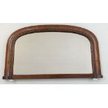 An Edwardian curved top overmantle mirror with china ball feet.