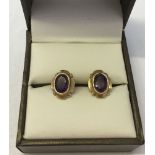 A pair of 9ct gold earrings set with oval amethysts. Approx weight 2.4g.