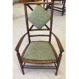 An arts & crafts beech nursing chair with ball casters and green upholstery.