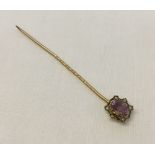 A Victorian gold stick pin set with central amethyst and 6 seed pearls (tests as 15ct).