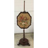 A Victorian mahogany firescreen on spiral pedestal leg with 3 scroll feet and brass casters.