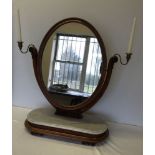 A Victorian oval mahogany framed mirror on marble base with brass candleholders. 66cm wide and