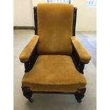 A Victorian library chair in gold upholstery.