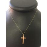 A 9ct gold engraved cross on an 18" chain. Weight approx 1.2g.