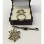 4 small items of silver jewellery to include a filligree flower brooch, 2 rings and an antique bar