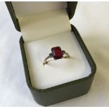 Vintage 9ct gold ladies dress ring set with a baguette cut red stone and 2 white stones in a silver