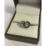 A silver dress ring set with black & white diamonds by TGGC. Size S.
