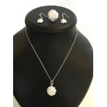 A silver set of matching jewellery of flower head design compising earrings, necklace and ring (size