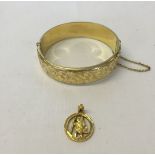 A nicely engraved rolled gold hinged bracelet togethet with a rolled gold St Christopher pendant.