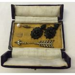 A box containing a pair of jet earrings, a pearl stick pin and a white metal past arrow.