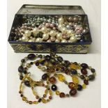 A tin of costume jewellery beads