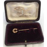 9ct gold stick pin in the shape of a horseshoe set with diamonds and rubies.