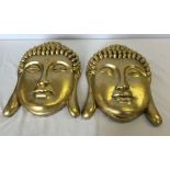 A pair of large gold wall hanging plaques of Buddha heads.