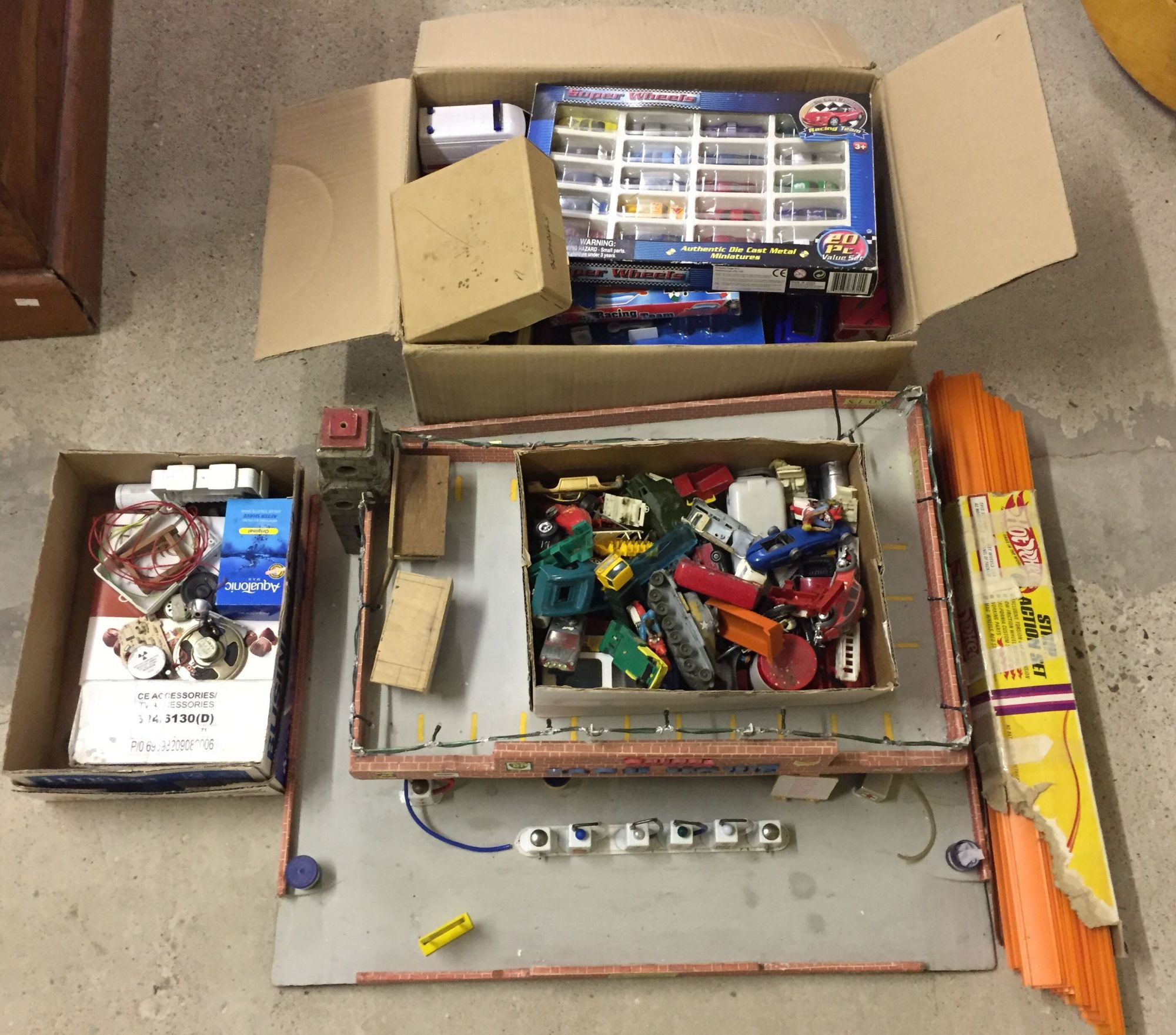 A vintage toy garage with lights, a box of assorted diecast cars and a box for spares/repair.