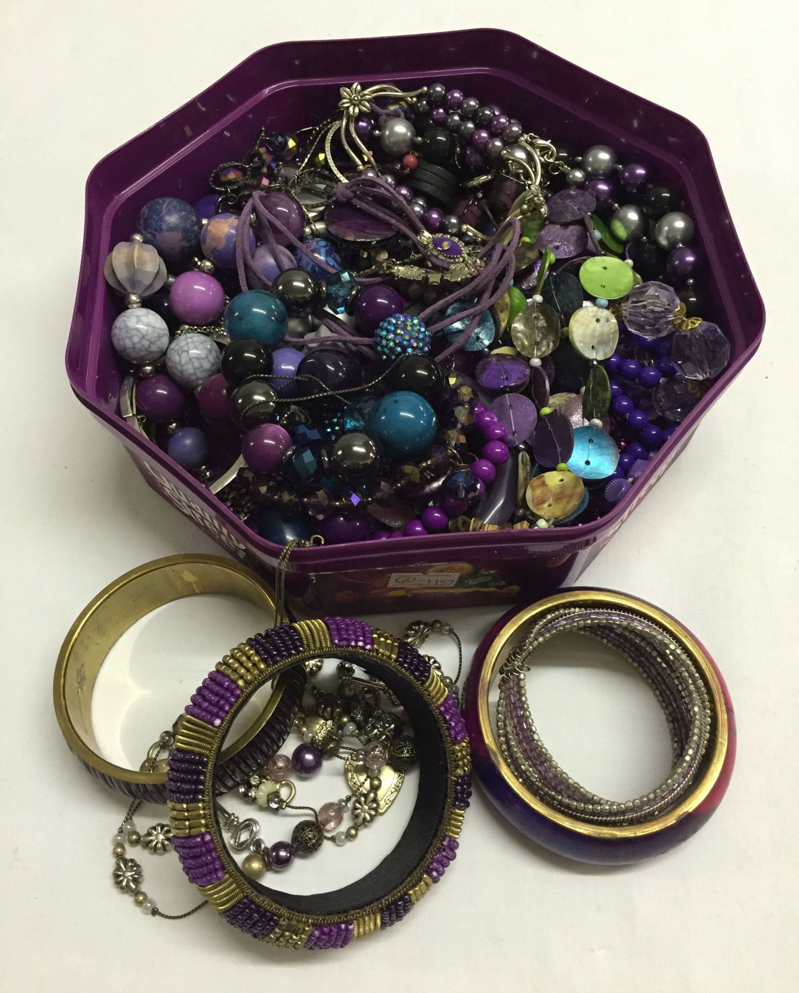 A tub of purple co-ordinated costume jewellery.