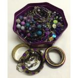 A tub of purple co-ordinated costume jewellery.