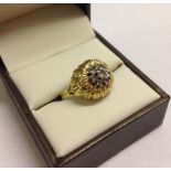 Ladies gold dress ring with a cluster of clear stones set in an unusual sunflower design mount. Size