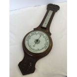 A carved oak wall hanging barometer. Glass a/f, approx 69cm long.