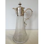 A cut glass claret jug with a silver plated handle & lid.