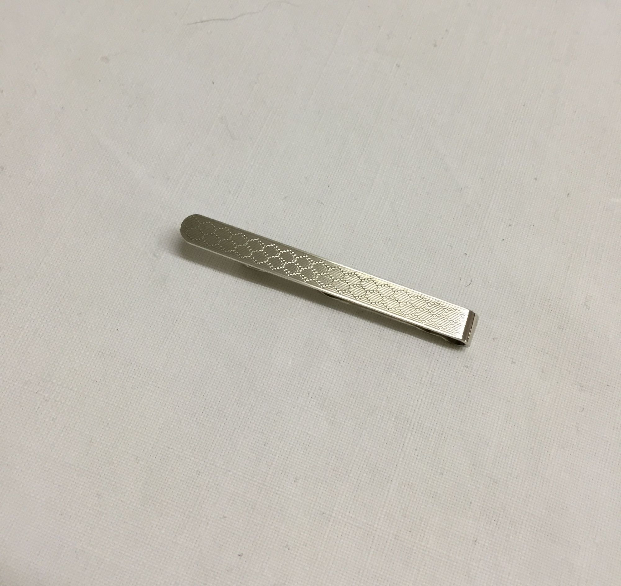 Hallmark silver tie bar with engine turned engraving.