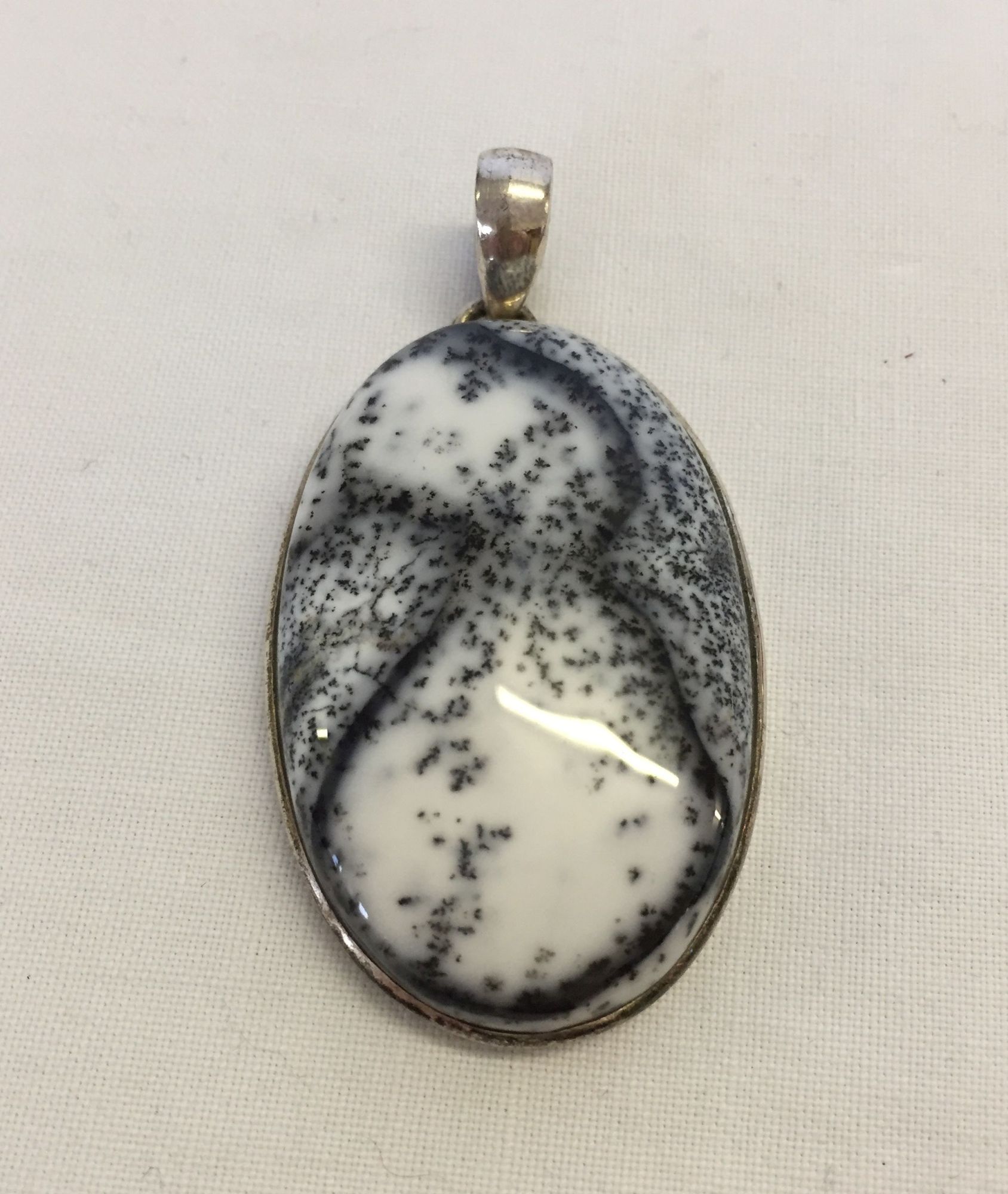 A large oval dendretic agate pendant set in 925 silver, total length 6cm.