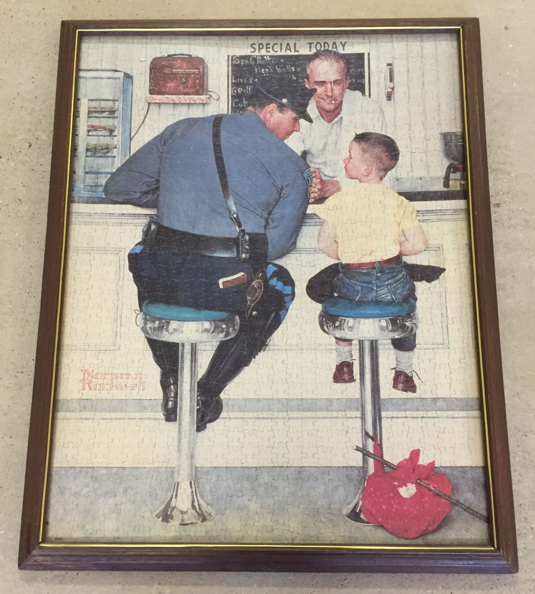 A large framed & glazed Norman Rockwell jigsaw, 59 x 71cm.