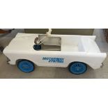 A vintage Tri-ang white Motorway Patrol pedal car. In need of restoration.
