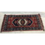 Red, blue and cream rectangular rug. Approx size 137cm x 66cm.
