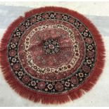 Red, cream and dark blue circular rug with fringing, approx 94cm in diameter.