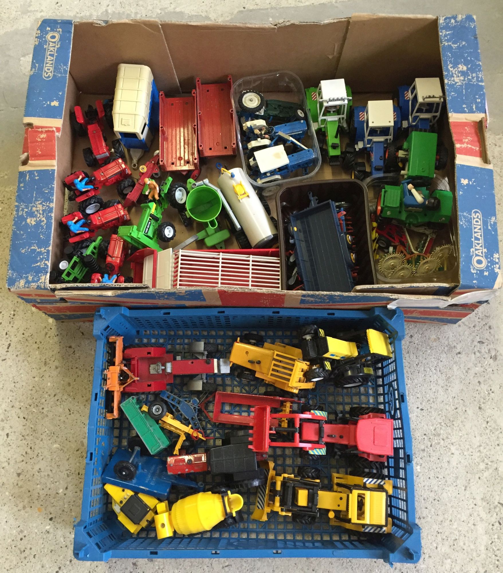 2 boxes of toy tractors and accessories.