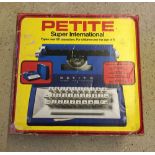 A boxed Petite Super International child's typewriter.
