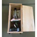 A student microscope in a wooden box.