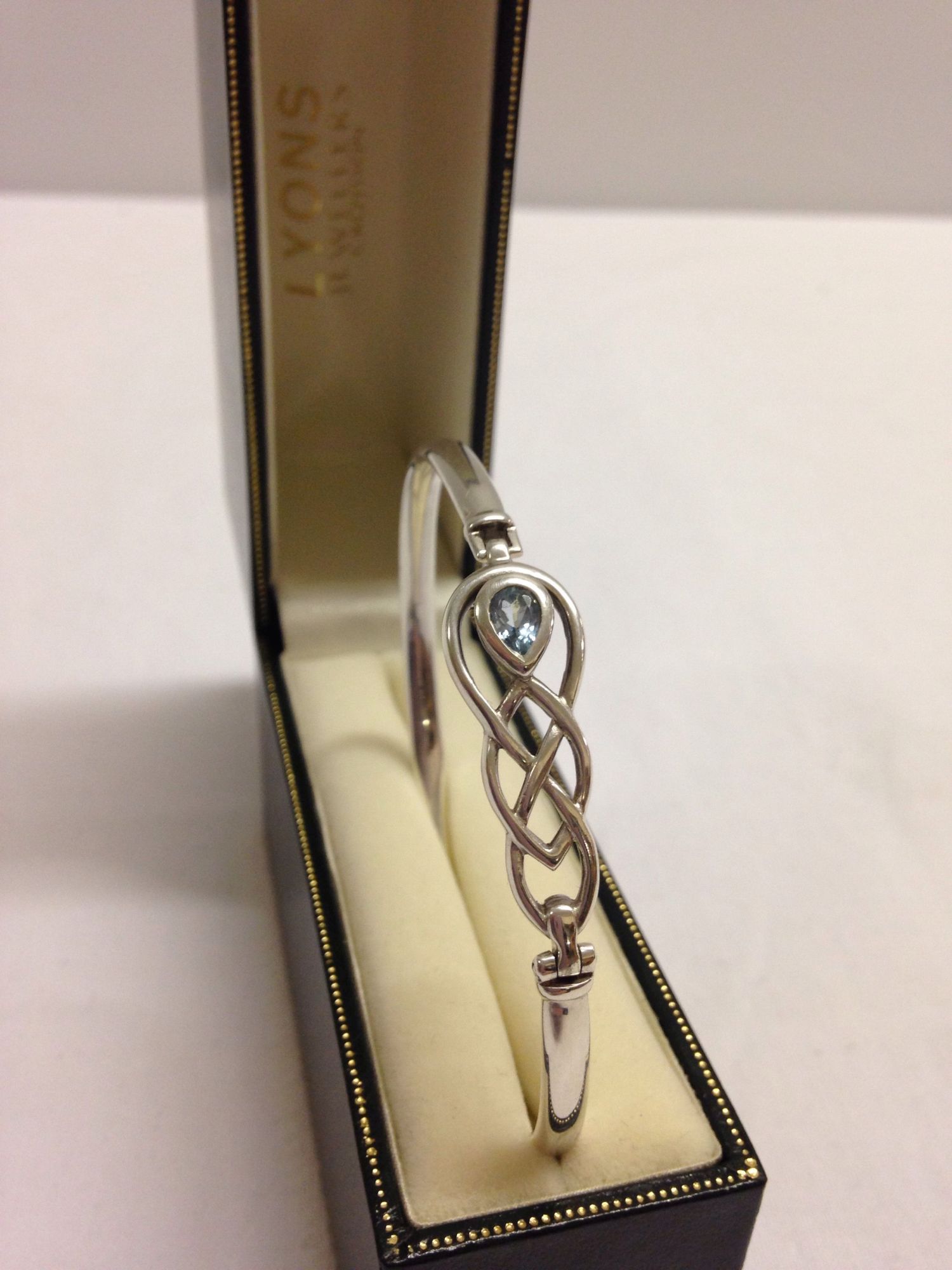 Hallmarked silver bangle with Celtic design, set with a blue topaz. Total weight approx 16.4g.