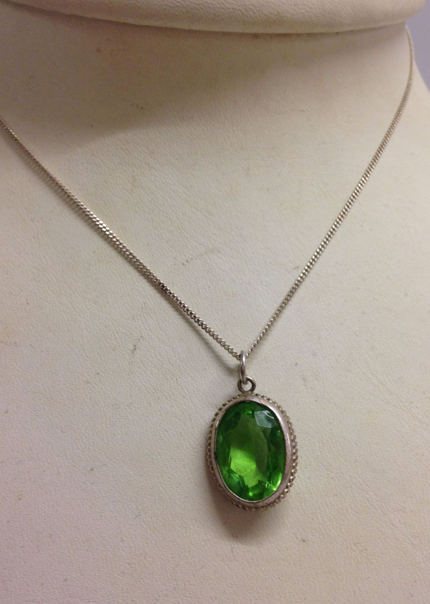 Large oval green kiwi topaz stone pendant on a 16" silver chain.