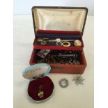 A red jewellery box containing a small amount of costume jewellery to include pendant watch on