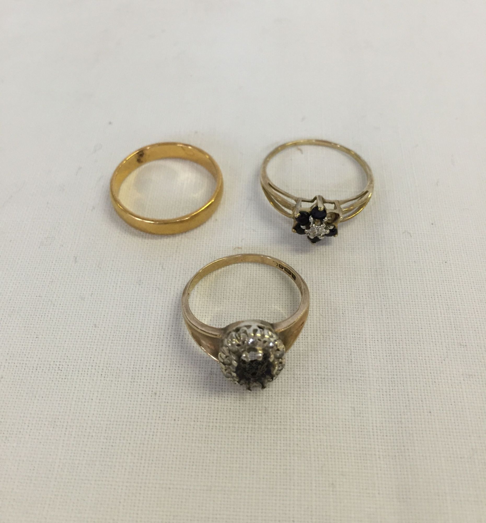 3 gold rings comprising a 22ct gold wedding band approx 3.2g and 2 9ct gold dress rings with missing