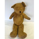 A large straw filled teddy bear with jointed arms and legs. Approx 75cm tall.